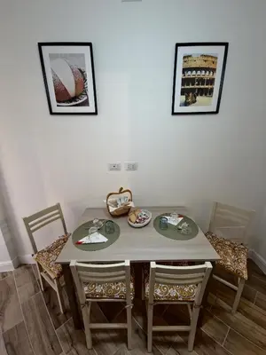 a dining room table with two chairs and a table and two pictures at Casa Milly in Rome