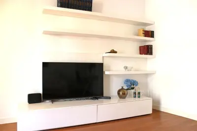 a living room with a white entertainment center with a flat screen tv at Roma Luxury Apartment in Rome
