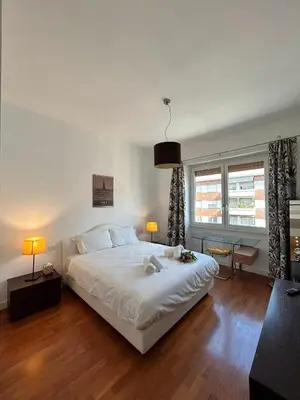 a bedroom with a large white bed and two windows at Roma Luxury Apartment in Rome