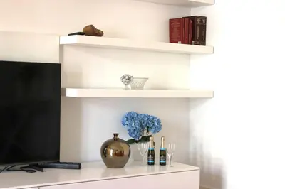 a living room with white shelves and a television at Roma Luxury Apartment in Rome