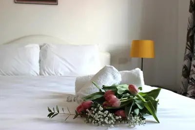 a bouquet of flowers sitting on top of a bed at Roma Luxury Apartment in Rome