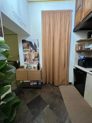 a kitchen with a table and a curtain in a room at S Angelo Apartment in Rome