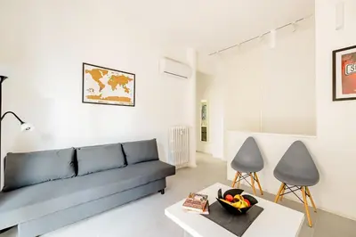 a living room with a blue couch and two chairs at Appartamento Moderno-H2OME nuovo in Rome