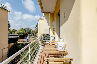 a balcony with wooden tables and chairs on a building at Appartamento Moderno-H2OME nuovo in Rome