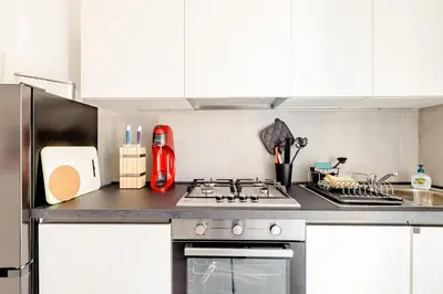 a kitchen with white cabinets and a stove top oven at Appartamento Moderno-H2OME nuovo in Rome