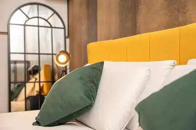 a bed with green and white pillows on it at Trastevere 1 in Rome