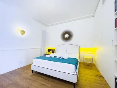 a white bedroom with a bed in a room at Gold Suite 5 minuti dal Colosseo in Rome