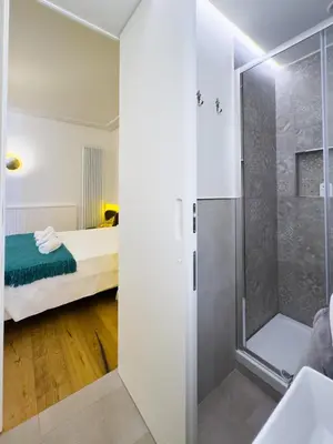 a bathroom with a shower and a bed in a room at Gold Suite 5 minuti dal Colosseo in Rome