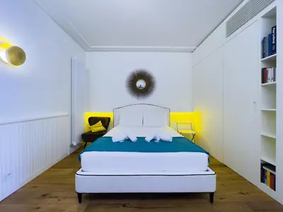 a white bedroom with a bed in a room at Gold Suite 5 minuti dal Colosseo in Rome