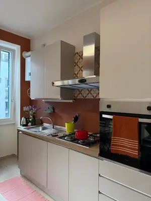 a kitchen with white cabinets and a stove top oven at Casa dei Parchi in Rome
