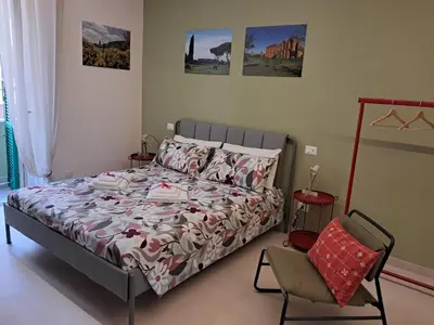 a bedroom with a bed and a chair in it at Casa dei Parchi in Rome