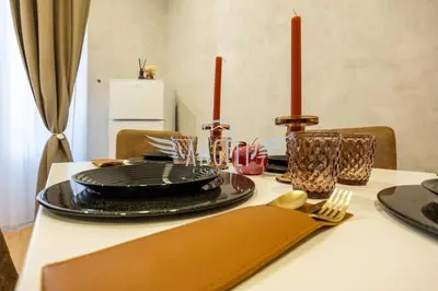 a dining room table with a black plate and red candles at BlueHouse Roma, ampia casa per gruppi e famiglie in Rome