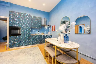 a blue room with a table and two mirrors at BlueHouse Roma, ampia casa per gruppi e famiglie in Rome