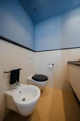 a bathroom with a white sink and a toilet at Courtyard Doria Comfort & Style at Vatican Museums in Rome