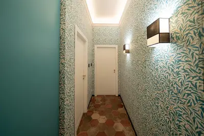 a hallway with blue walls and a white door at Courtyard Doria Comfort & Style at Vatican Museums in Rome