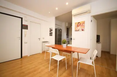 a dining room with a wooden table and white chairs at Maison Tiburtina by Ghor in Rome