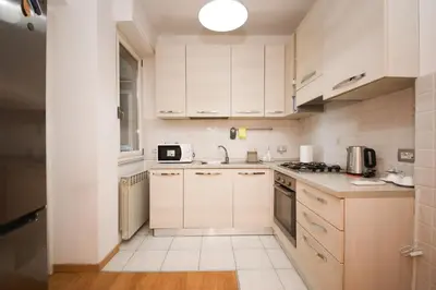 a kitchen with white cabinets and a stove top oven at Maison Tiburtina by Ghor in Rome