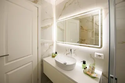 a white bathroom with a sink and a mirror at Boncompagni Serenity Suites in Rome