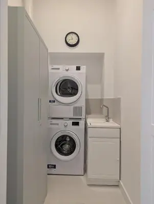 a laundry room with a washer and dryer and a clock at Ostiense 353 Apartment by RS in Rome
