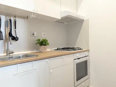a white kitchen with a sink and a stove at Ostiense 353 Apartment by RS in Rome