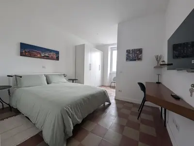 a white bedroom with a bed and a desk at Ostiense 353 Apartment by RS in Rome