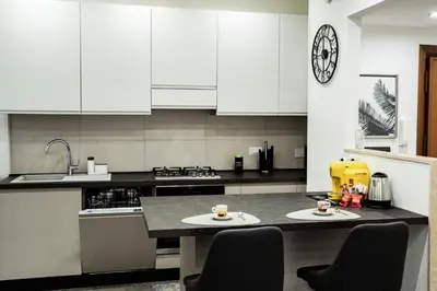 a kitchen with white cabinets and a table with two cups on it at Vaticano-Cornelia Luxury Home in Rome