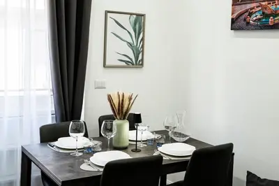 a dining room table with chairs and a table with wine glasses at Vaticano-Cornelia Luxury Home in Rome