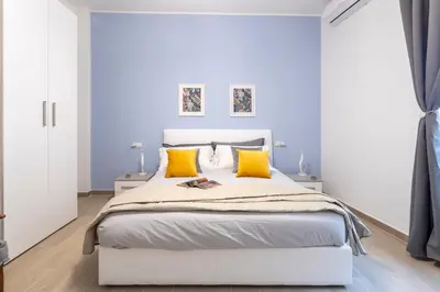 a bedroom with a large white bed with yellow pillows at Vigna Clara apartment in Rome