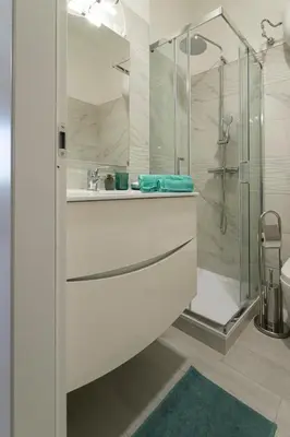 a white bathroom with a shower and a sink at Vigna Clara apartment in Rome