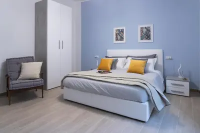 a bedroom with a white bed and a chair at Vigna Clara apartment in Rome