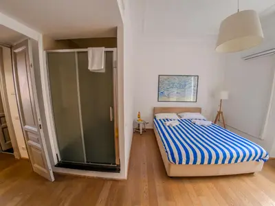 a bedroom with a bed and a glass shower at Pop Apartment in the Heart of Trastevere 4 Guests in Rome