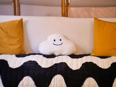 a stuffed cloud sitting on top of a bed at Pop Apartment in the Heart of Trastevere 4 Guests in Rome