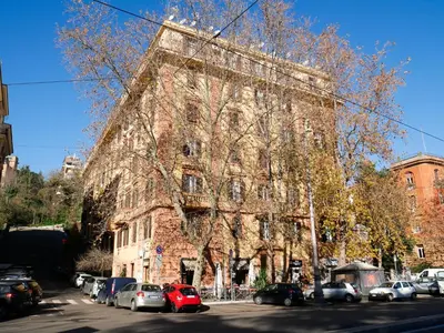 a large brick building with cars parked in front of it at Pop Apartment in the Heart of Trastevere 4 Guests in Rome