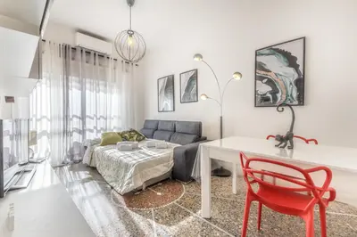 a living room with a couch and a table and a red chair at Asinari Retreat in Rome