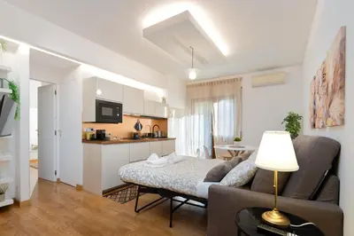 a living room with a couch and a kitchen at Your Place in Rome Apartments in Rome
