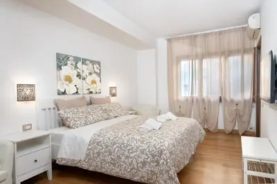 a white bedroom with a bed and a window at Your Place in Rome Apartments in Rome