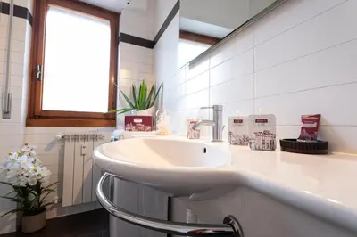 a white bathroom with a sink and a window at Graffiti Sweet Home in Rome