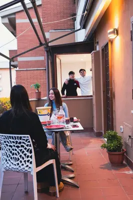 a group of people sitting at a table on a patio at Graffiti Sweet Home in Rome
