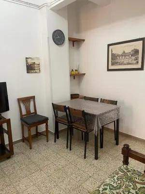 a dining room with a table and chairs and a clock at Vatican Time apartment in Rome