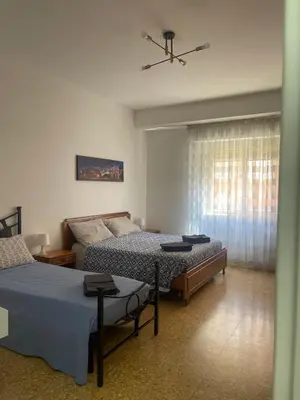 a bedroom with two beds and a window at Vatican Time apartment in Rome