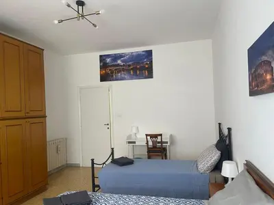 a bedroom with two beds and a table in it at Vatican Time apartment in Rome