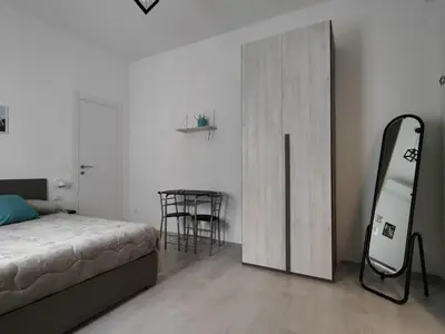 a bedroom with a bed and a mirror and a table at Rome Cozy Room in Rome
