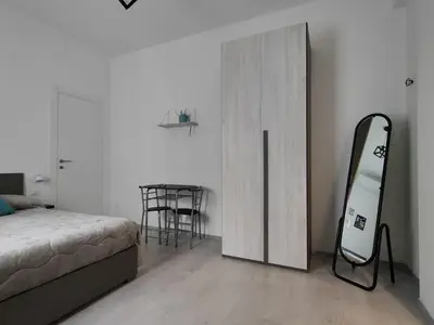 a bedroom with a bed and a mirror and a table at Rome Cozy Room in Rome