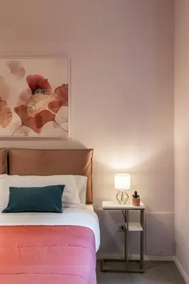 a bedroom with a bed and a table with a lamp at GF Harmony Suite Colosseo in Rome
