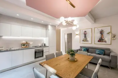 a kitchen and living room with a table and a couch at GF Harmony Suite Colosseo in Rome