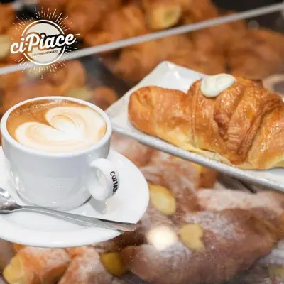 a cup of coffee and a croissant on a plate at San Silverio B&B in Rome