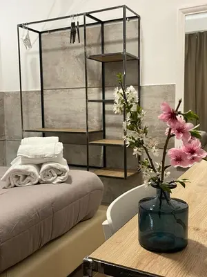 a room with a table with a bed and a vase with flowers at San Silverio B&B in Rome