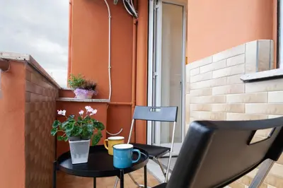 a small balcony with a table and a chair at Saulo Boutique Apartment in Rome