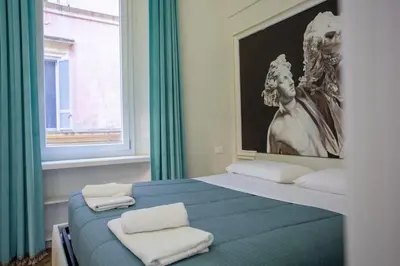 a bedroom with a blue bed with two white towels at Spanish Steps Luxury Apartment in Rome