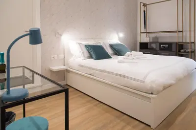 a bedroom with a large white bed with blue pillows at Colosseum suites by Glen in Rome